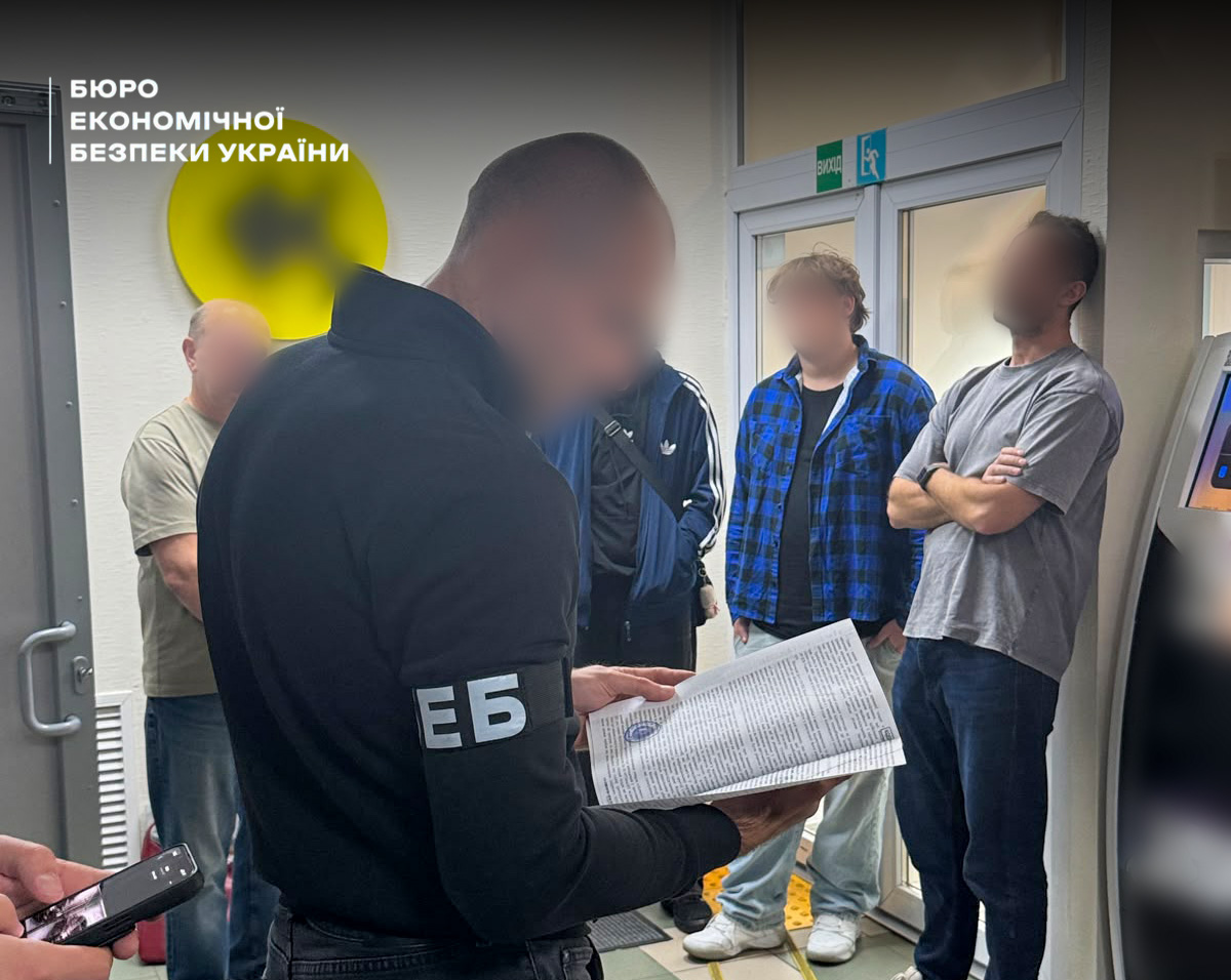 An inspection and search in the premises of a shadow exchange office. A ESBU detective holds open papers in front of three suspects.