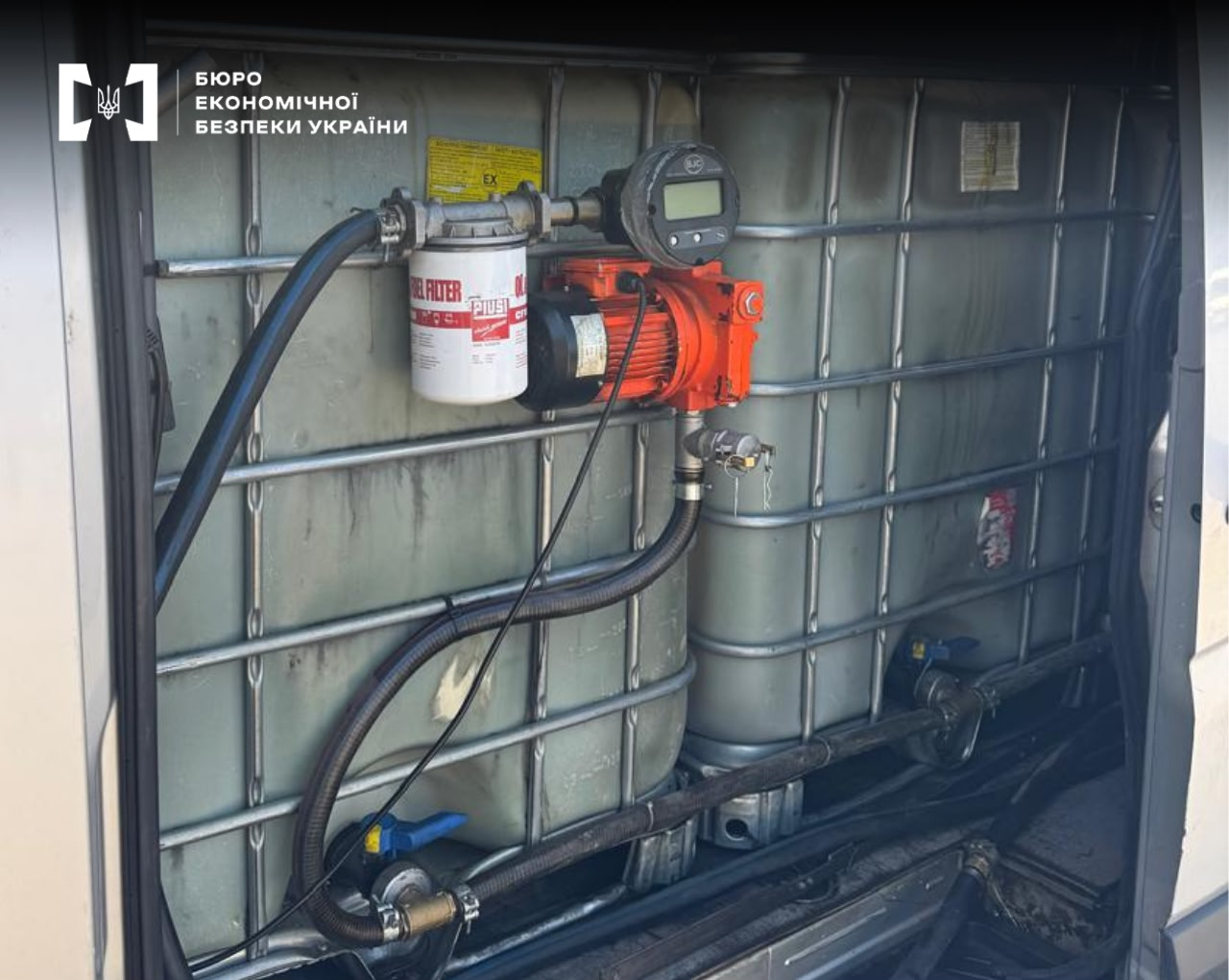 Illegal gas station equipment: a PIUSI pump station and a fuel filter mounted on the metal frame of large white tanks