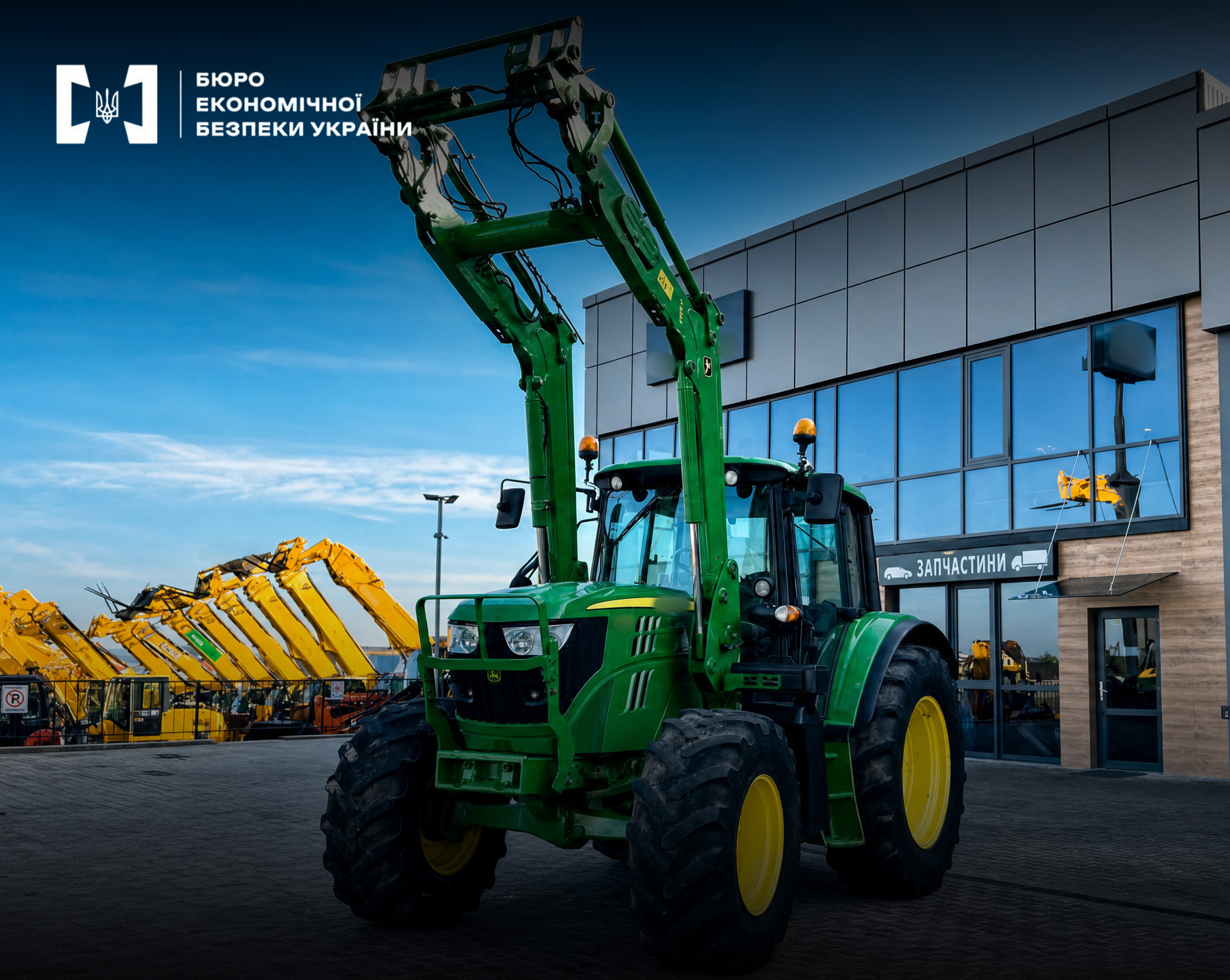 A green John Deere tractor with a raised loader near a building.