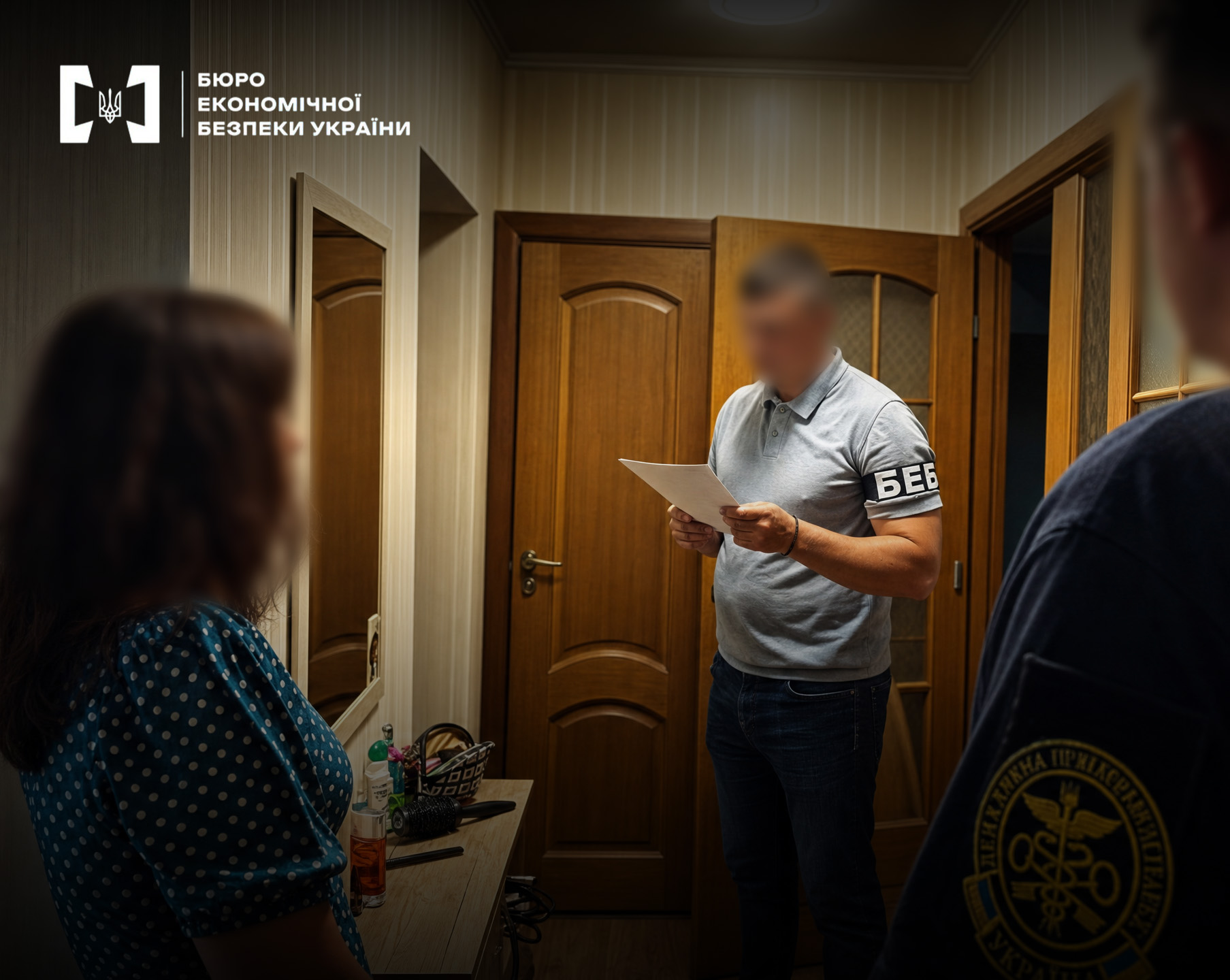 An ESBU detective reads out documents during investigative actions in an apartment.