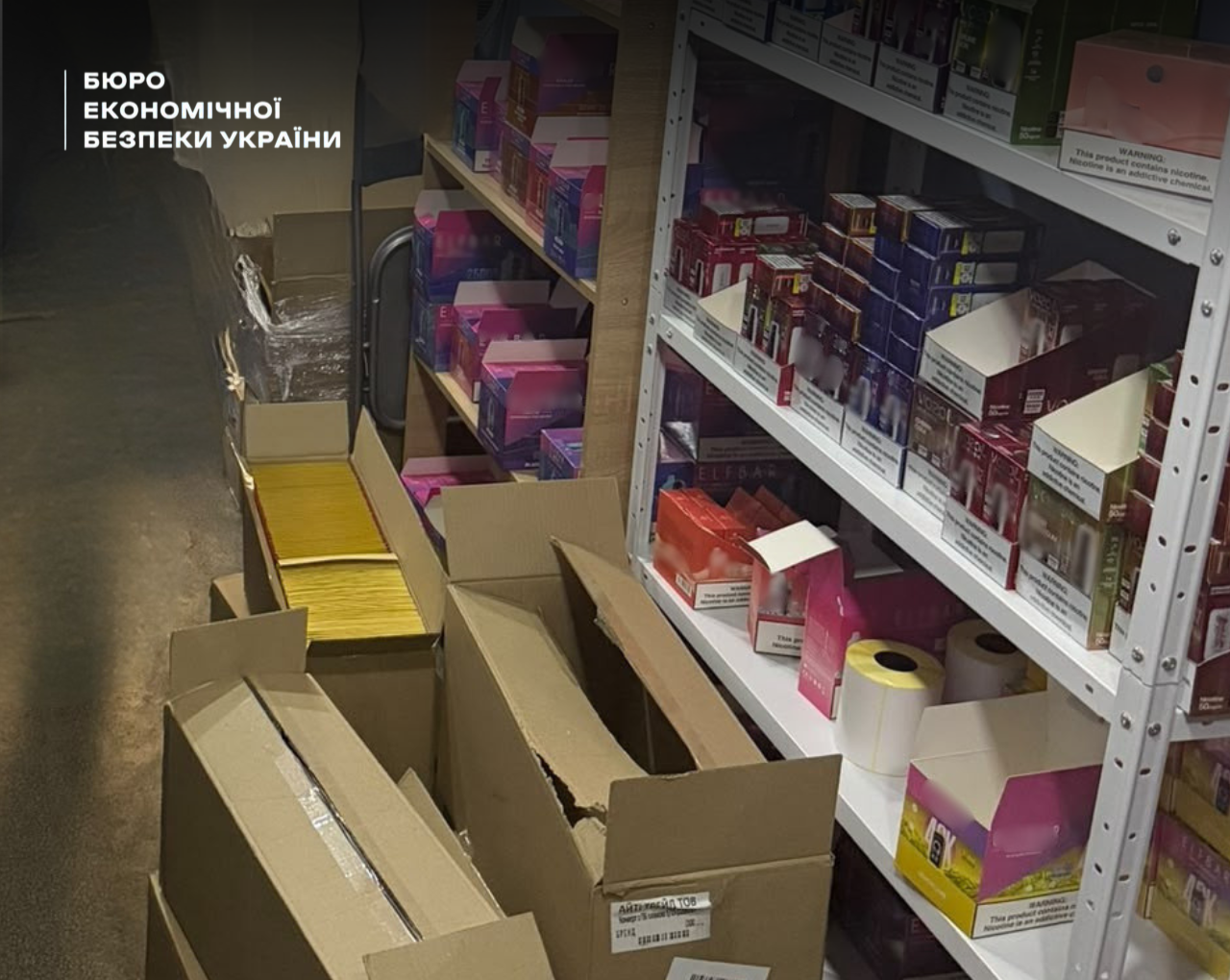 Multi-coloured packs of vapes and disposable cigarettes on white metal shelving units in a utility room