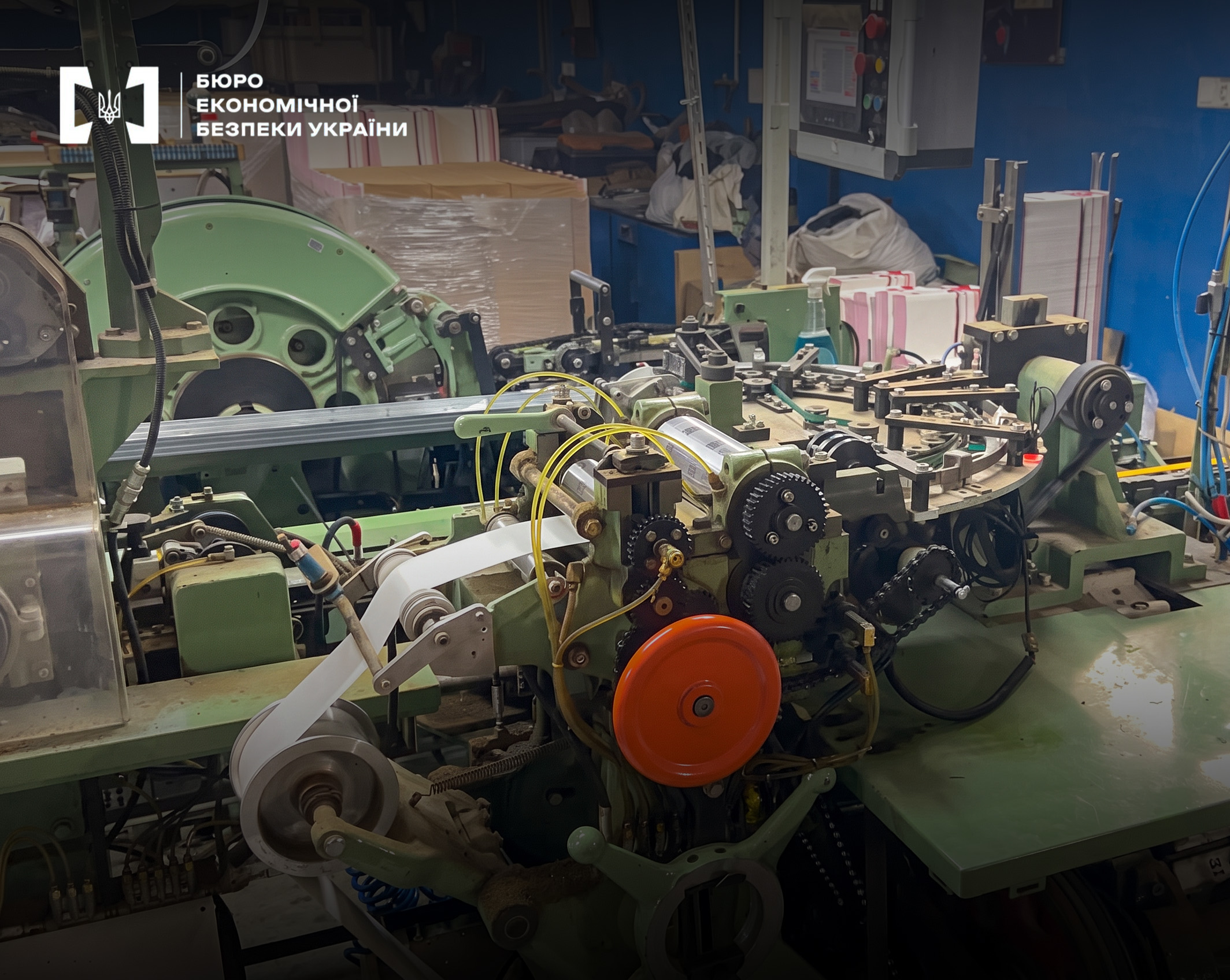 An industrial machine with a roll of white paper in an underground cigarette workshop.