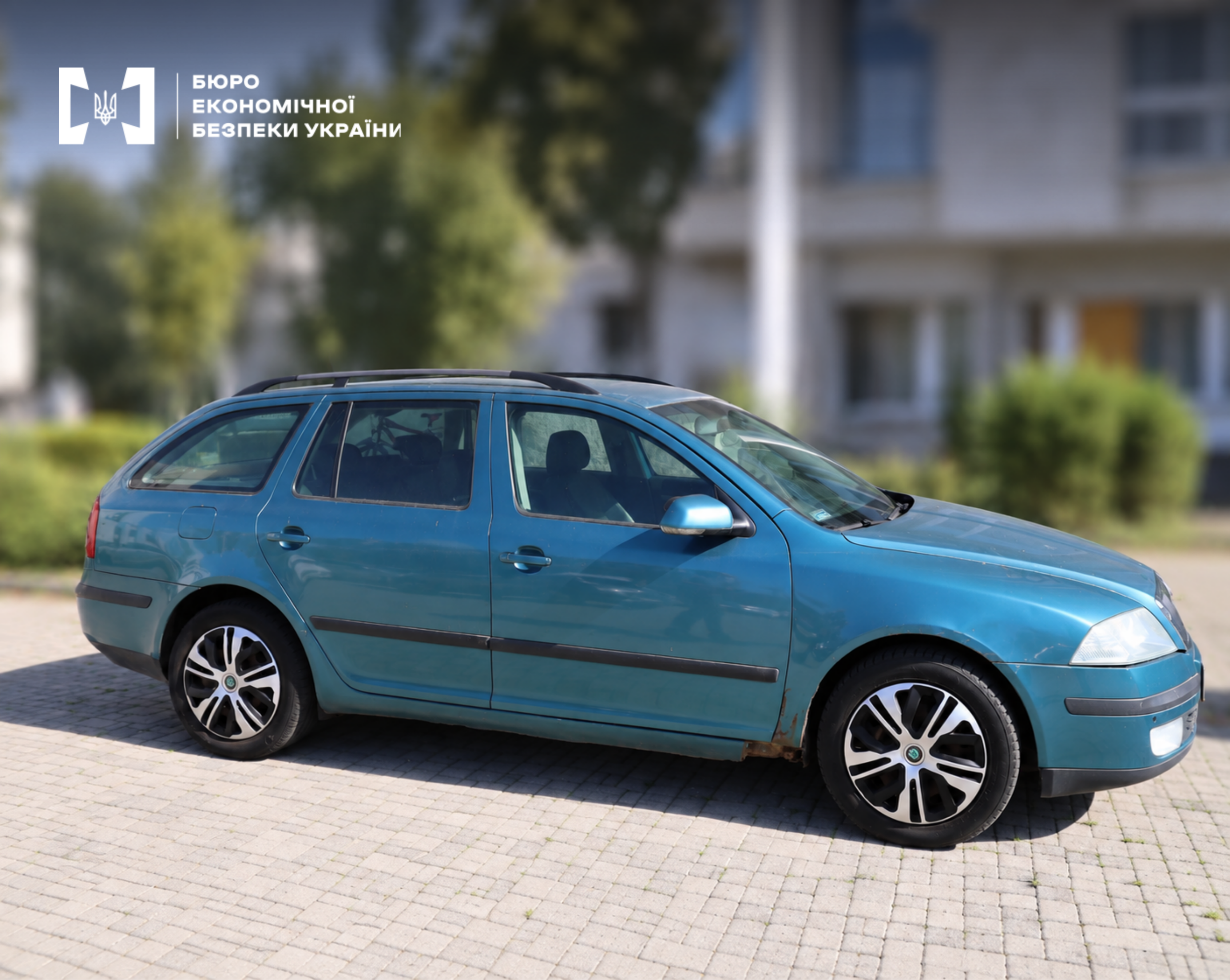 A blue-green Skoda Octavia Combi car with alloy wheels at an impound lot.