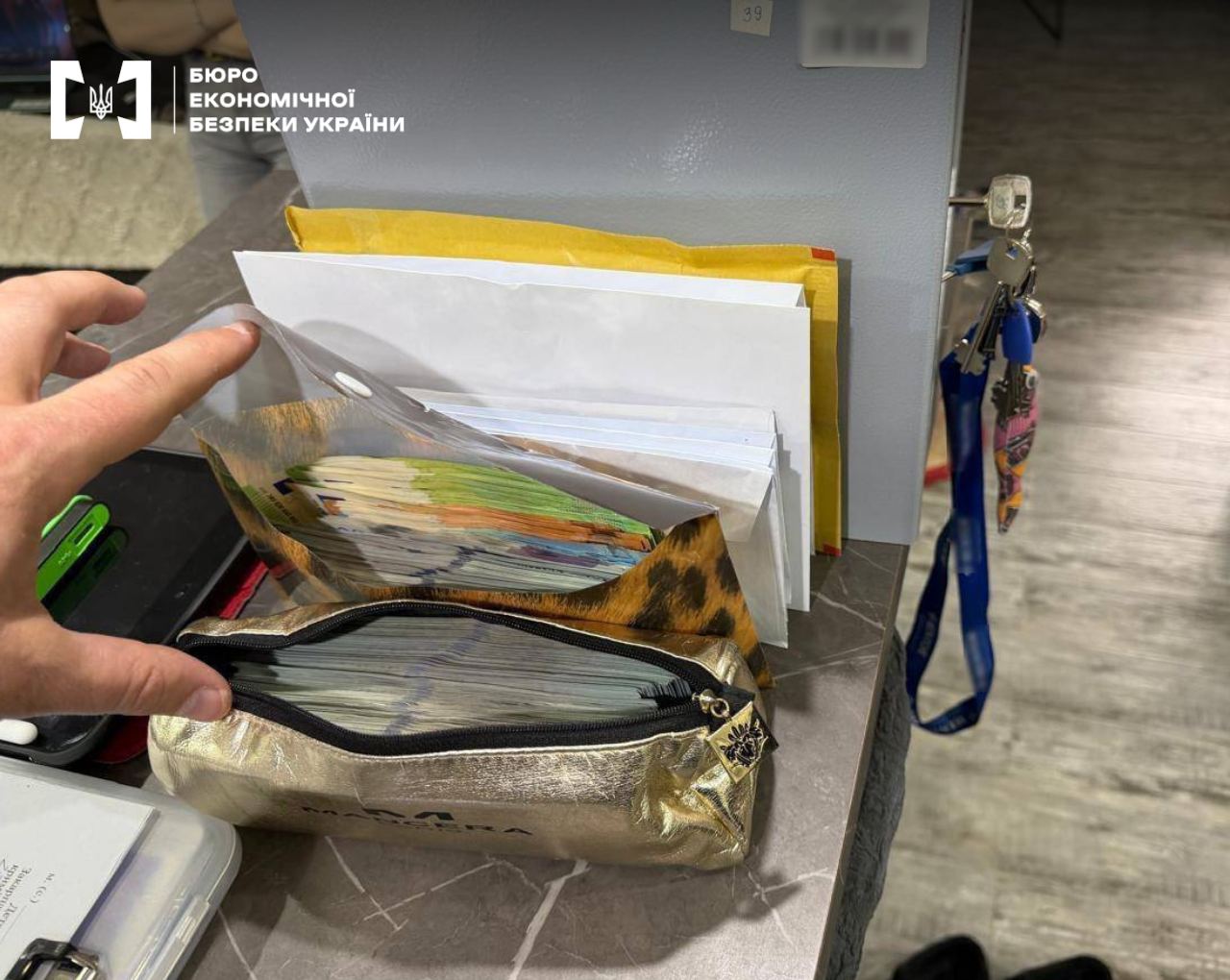 Bundles of banknotes are located inside a shiny gold cosmetic bag and paper envelopes