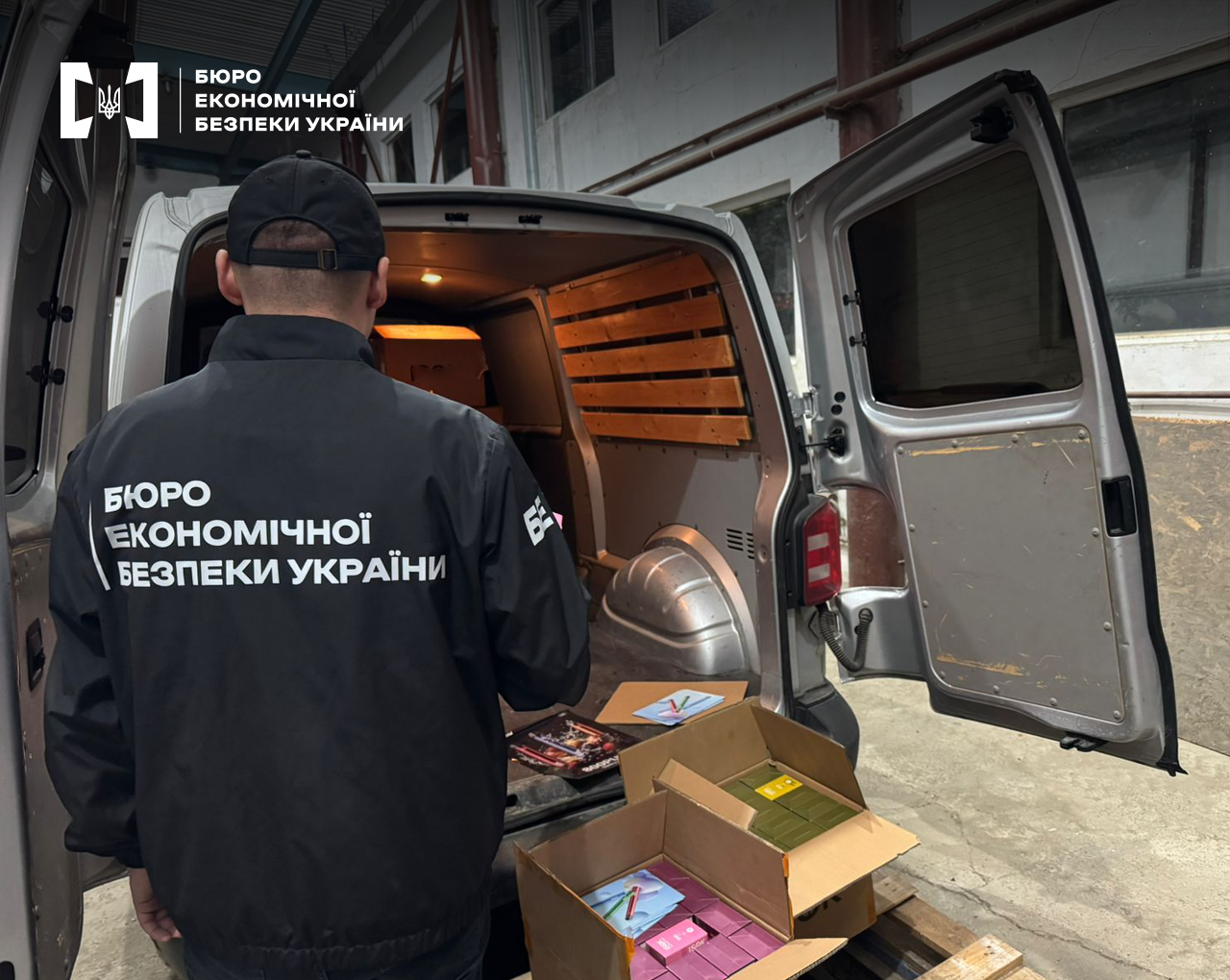 Детектив БЕБ оглядає вантаж у відкритому фургоні: видно кілька коробок на підлозі, деякі з них розкриті