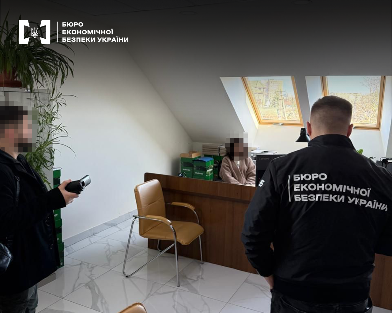 Детективи БЕБ проводять слідчі дії в офісі. Мансардне приміщення, жінка за робочим столом. Обличчя заблюрено.