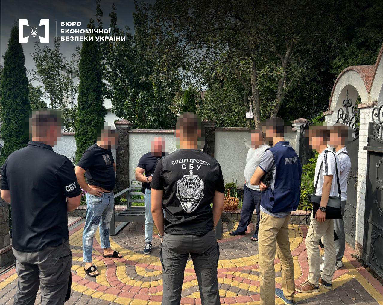 Спільна операція правоохоронців. 8 чоловіків у приватному дворі, який викладений кольоровою бруківкою та огороджений парканом. Навколо ростуть дерева.