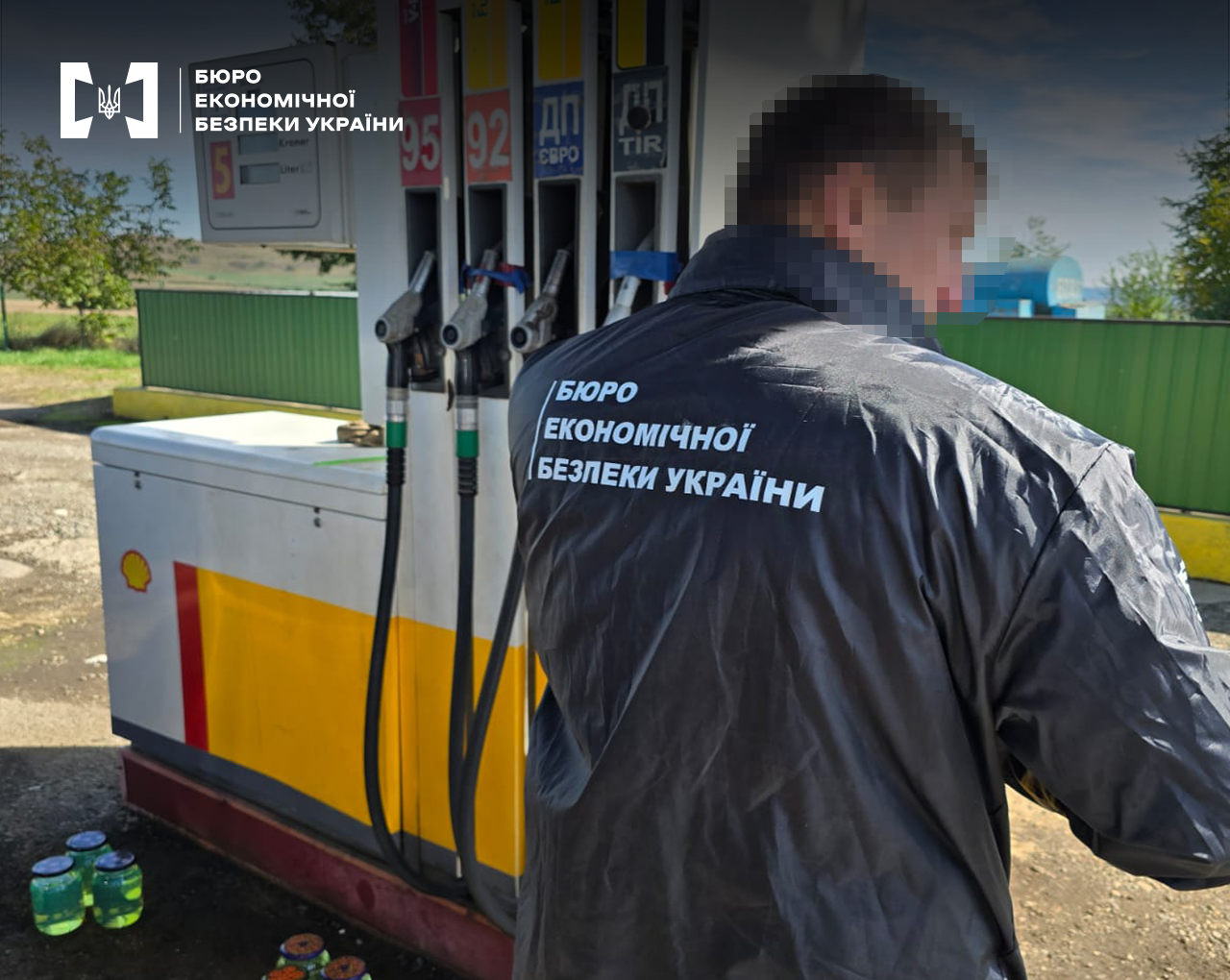 Детектив БЕБ відбирає зразки палива з колонки на АЗС.